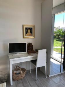 escritorio blanco con monitor de ordenador y silla en Villa Tropical, en Francavilla al Mare