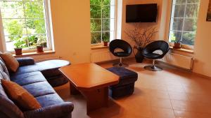 a living room with a couch and two chairs and a tv at APARTMÁNY POD ČERCHOVEM in Trhanov