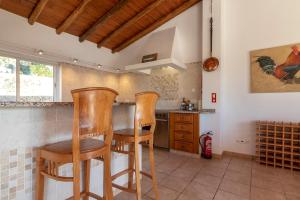 una cocina con 2 sillas de madera y una mesa en Villa Diane Luxury Cottage Ocean views pool, en Benagil