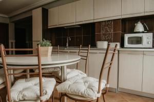 a kitchen with a table and chairs and a microwave at Orbisa Bis in Łeba