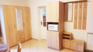 a kitchen with wooden cabinets and a microwave at APARTMÁNY POD ČERCHOVEM in Trhanov