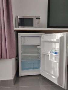 a refrigerator with its door open next to a microwave at Stunning Double Room in Harrow Wembley - Khoob House in London
