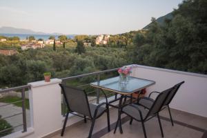 a table and chairs on a balcony with a view at Elina's Maisonette in Episkopos