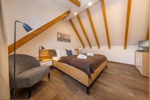 a bedroom with a bed and a chair at Suite Strandluft in Zingst