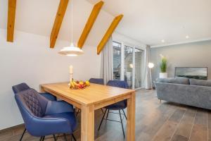 a dining room with a wooden table and blue chairs at Suite Strandluft in Zingst