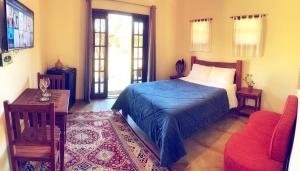 1 dormitorio con 1 cama, 1 mesa y 1 silla en Recanto Roça Grande, en Cunha