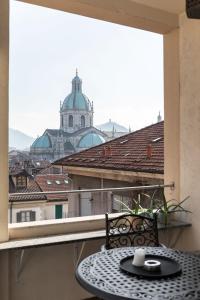 una mesa en un balcón con vistas a un edificio en Como Bellevue Duomo, en Como
