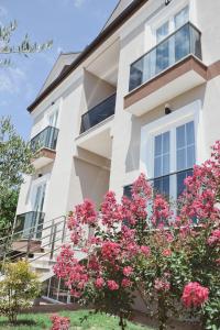 a white building with pink flowers in front of it at Airport Garden Hotel in Rinas