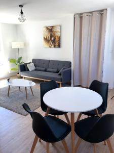 sala de estar con sofá, mesa y sillas en Appartement calme & lumineux proche centre, en Saumur