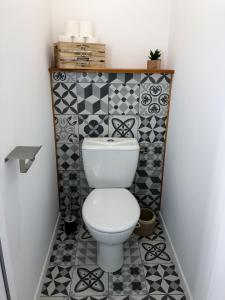 uma casa de banho com WC num quarto com azulejos em Appartement calme & lumineux proche centre em Saumur