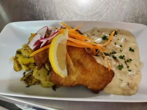 a plate of food with fish and potatoes on a table at Landhaus Bisping in Everswinkel +25 photos