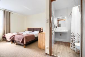 a bedroom with a bed and a bathroom with a sink at Hotel Bosak in Szczecin