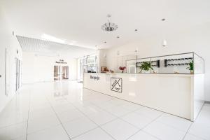 a large white room with a white tile floor at Hotel Bosak in Szczecin