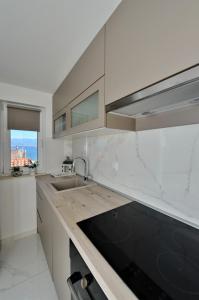 une cuisine blanche avec un évier et une fenêtre dans l'établissement Apartmani Laura Vir, à Vir