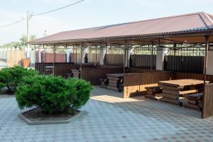 a pavilion with a picnic table and a bench at Veles Klub Guest House in Peresyp