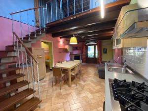 cocina y sala de estar con mesa y escalera en Agriturismo Il Casale, en Morrovalle