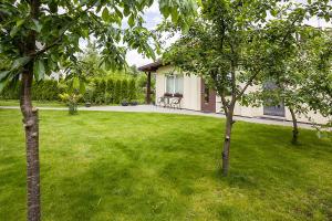 a house with a yard with green grass and trees at Agnės svečių namai in Kaunas