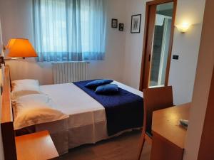 a bedroom with a bed with blue pillows on it at La Ruota in Morbegno