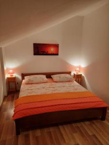 a bedroom with a bed with two lamps on two tables at Apartment Rozalija in Šibenik