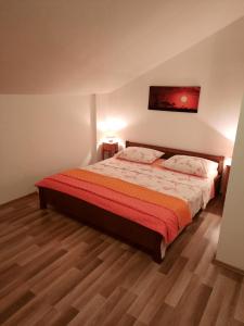 a bedroom with a large bed with a red blanket at Apartment Rozalija in Šibenik