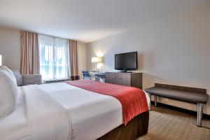 a hotel room with a bed and a flat screen tv at Comfort Inn & Suites South in Calgary