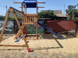 a playground with a slide in the sand at Катюша морская in Zatoka