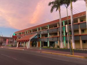 um edifício numa rua com uma palmeira em Hotel La Finca em Hermosillo