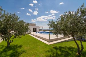 a villa with a swimming pool and two trees at Villa Olive`s secret in Kastel Luksic