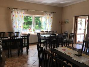 a dining room with tables and chairs and windows at U Eli in Wambierzyce