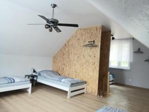 a bedroom with two beds and a ceiling fan at Agro-Luz in Miastko