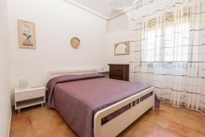 a small bedroom with a bed and a window at Casa Vacanza Sant'Erasmo Ginosa Marina in Ginosa Marina