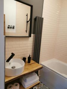 uma casa de banho com um lavatório branco e uma banheira em Central Park Studio Petrosani em Petroşani