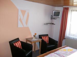 a bedroom with two chairs and a tv on the wall at Haus-Anka in Cochem