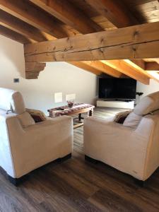 a living room with two chairs and a table at B&B Stella Alpina in Fontanelle