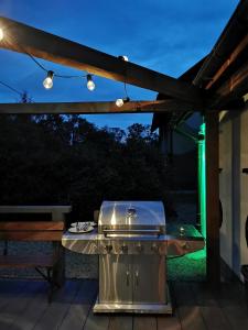 a grill on a patio under a pergola at night at Ośrodek VolfCamp Kwaszenina in Arłamów