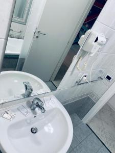 La salle de bains est pourvue d'un lavabo blanc et d'un miroir. dans l'établissement B&B Adc home, à Ercolano