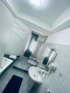 La salle de bains blanche est pourvue d'un lavabo et de toilettes. dans l'établissement B&B Adc home, à Ercolano