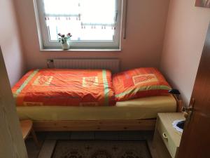 małe łóżko w małym pokoju z oknem w obiekcie Ferienhaus Kleymann w mieście Sögel