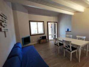 a living room with a table and a blue couch at Villetta Graziosa sul mare ristrutturata in Fort Village