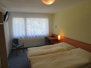 Postel nebo postele na pokoji v ubytování Hotel Klausenhof Flüeli