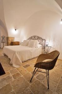 a bedroom with a white bed and a chair at Malandrì in Altamura