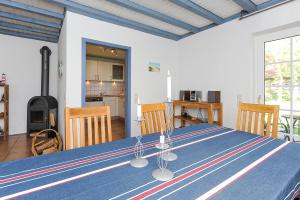 a dining room with a blue table and a kitchen at Huus Tide in Werdum