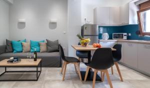 a kitchen and living room with a couch and a table at Karavos Apartments Almyros in Almiros Beach