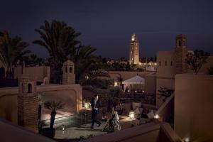 a man and woman walking around a courtyard at night at Royal Mansour Marrakech in Marrakesh