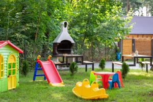 a group of childrens play equipment in the grass at Domki Amare in Pobierowo