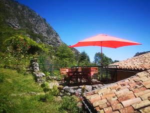 uma mesa e cadeiras com um guarda-sol no telhado em la maison sous le château em Montségur