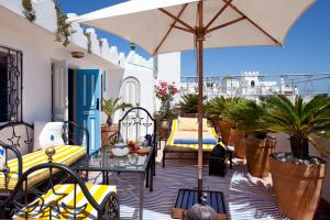 um pátio com uma mesa e um guarda-sol em Dar Sultan em Tânger