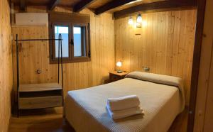 a bedroom with a bed with two towels on it at Casa rural Alcala Cabaña Del herrero in Alcalá del Júcar