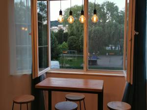 a window with a table and stools in front of it at Central Park Studio Petrosani in Petroşani