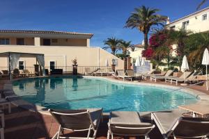 Una gran piscina con sillas y un edificio. en Front line townhouse Face la mer in Ferragudo luxury sea views, en Ferragudo